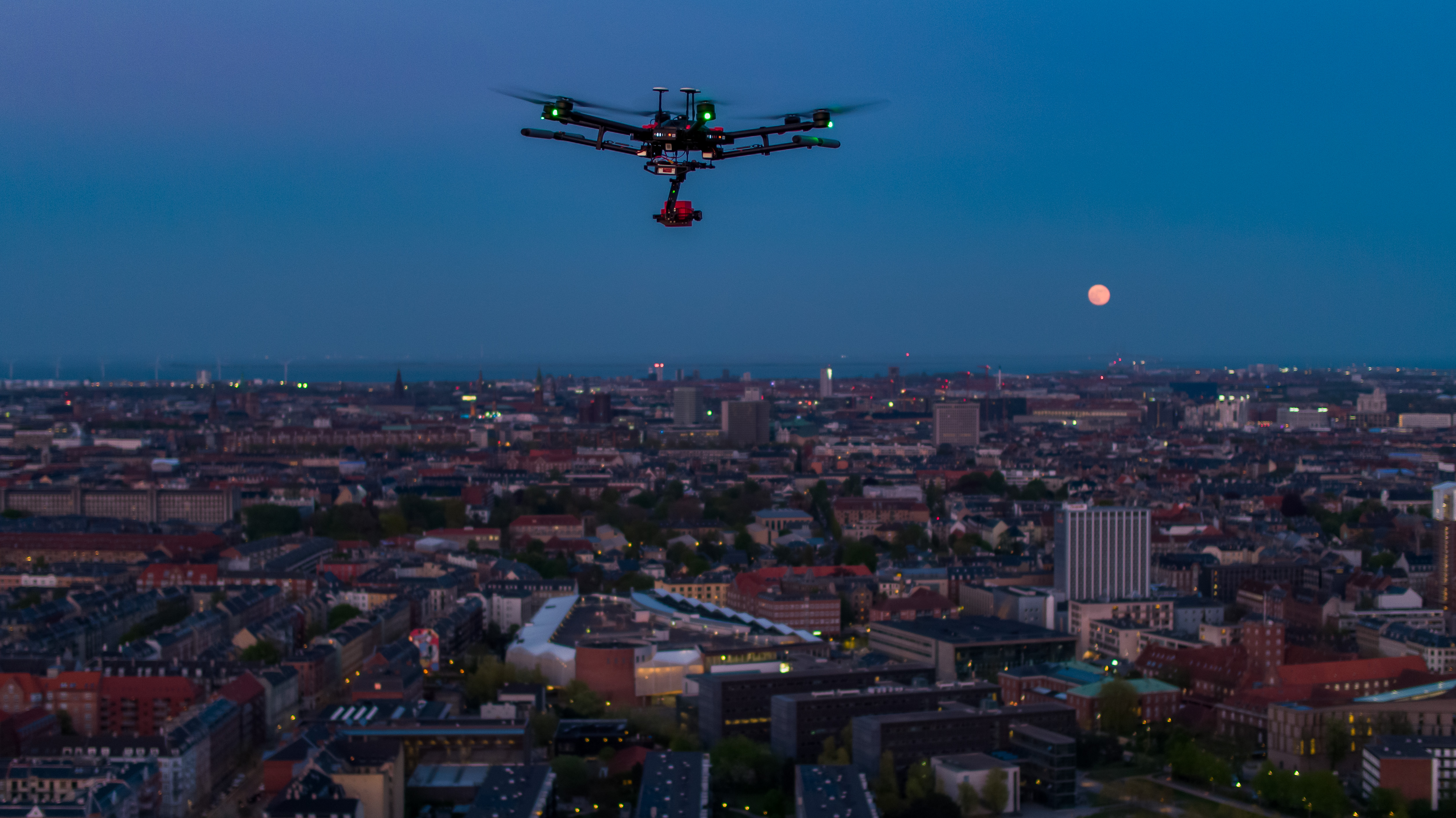 Drone i luften over en by - Foto af Drone Systems